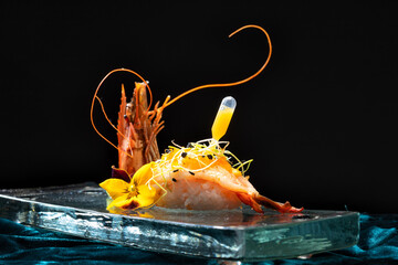 High-end nigiri sushi with a fresh shrimp, artistically decorated with microgreens, edible flowers,...