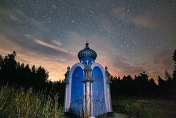 Night starry sky above the obelisk standing on the border of two parts of the world "Europe-Asia". Kedrovka village, Kushvinsky urban district, Ural. August 2025.