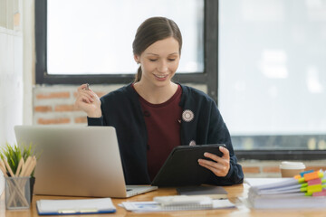 Portrait of a happy businesswoman working with a laptop in an office.