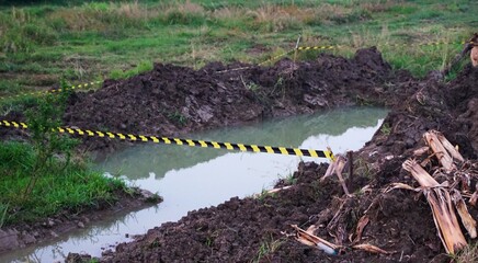 a hole from an excavation that is filled with water and marked with a boundary