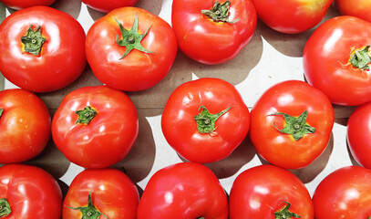 Red tomato background close-up on market table as vegetable abstract background