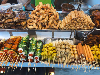 Colorful display of Thai street food with skewers, fried shrimp and spring rolls. Concept of culture, variety, community, tradition, flavor and lifestyle.