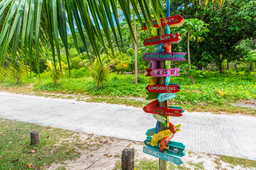 Directions signpost under a palm tree in a tropical island