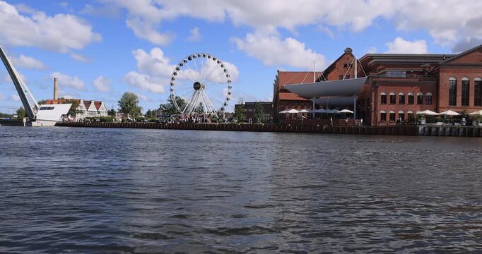 Gdansk Poland water front ferris wheel draw bridge 4K. Baltic coast northern Poland. World War II started here German invasion. Economic international port. Historical buildings, tourist attractions.
