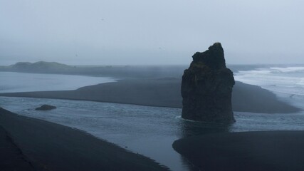 Misty Black Sand Beach with Basalt Sea Stack in Iceland