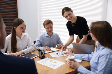 Business coach giving presentation to group of people in office