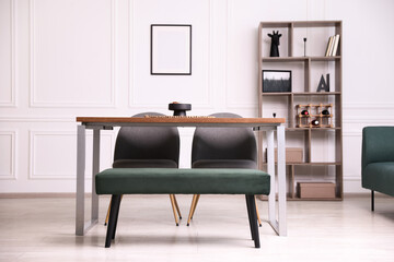 Wooden table with chairs, bench and decor in dining room. Interior design