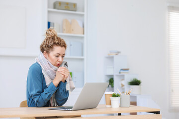Air conditioning. Woman with scarf suffering from cold temperature at workplace in office
