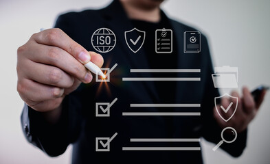 Quality control and ISO compliance concept in modern business, showing a businessman checking tasks on a virtual checklist to ensure standards, certification, and data accuracy.