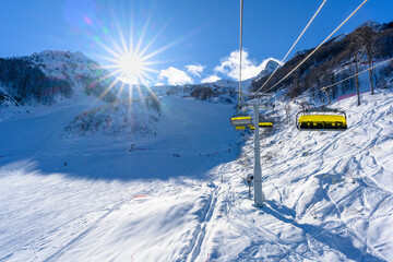 Cable car cabins against snowy mountains and clear skies