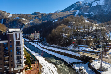 Winter resort on mountain hillside and mountain river