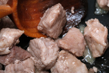 Cooking juicy pork chunks in a skillet with care 