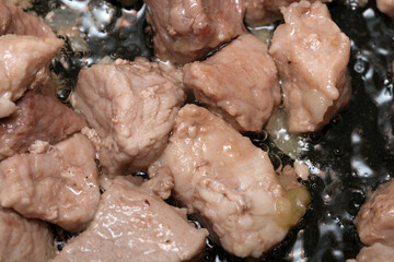 Juicy morsels sizzling in a hot pan for a hearty dish 