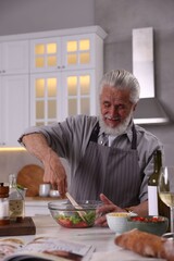 Elderly man cooking at table in kitchen