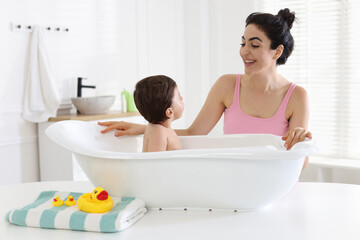 Mom giving bath to her little baby at home