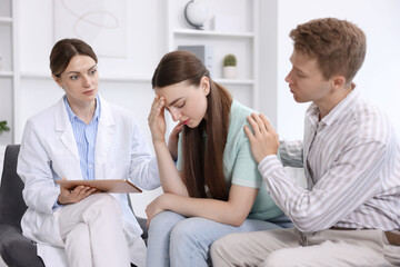 In vitro fertilization (IVF). Upset couple having appointment with doctor in reproductive clinic