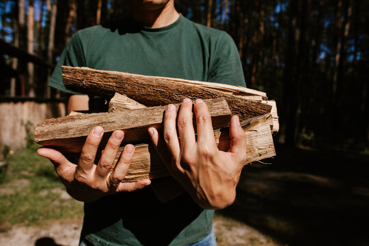 Lumberjack carrying firewood in forest for winter heating