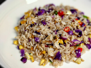 close up of fried rice with vegetables, egg and chili in a white bowl