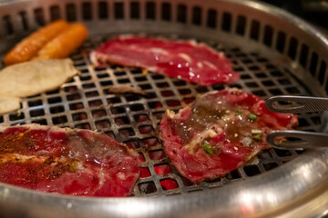 Sliced brisket on the  grill. BBQ rare meat with soft focus