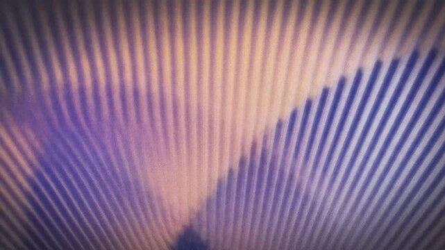 Abstract pattern of parallel lines creating a dynamic visual effect with gradients of purple and orange light.