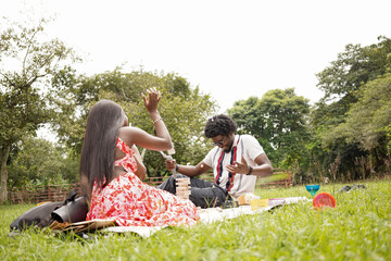 Three friends having a picnic at the park on a bright summer day 