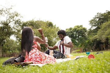 Three friends having a picnic at the park on a bright summer day 