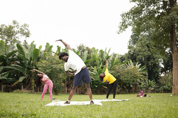 Three young friends working out in the open field at the park