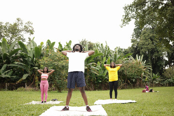 Three young friends working out in the open field at the park