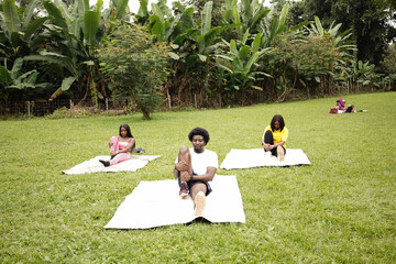 A small group of friends stretching after a workout at the park