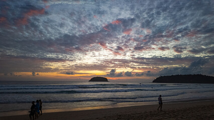 Island Glow at Kata Beach Phuket. The last rays of sunshine illuminate the clouds with vibrant...