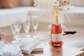 bottle of champagne next to glasses on a table