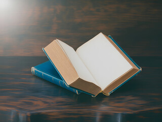 Classic blue hardcover book placed on a wooden surface with blank pages awaiting a story to be written