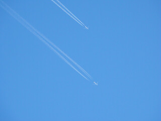 White streaks of planes leave behind like clouds crossing the image diagonally across the...