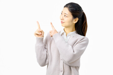 指さしポーズで案内する若い女性