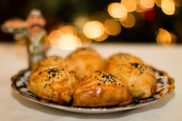 Uzbek pastries samsa arranged beautifully on a decorative plate, showcasing golden crusts and black sesame seeds, perfect for culinary enthusiasts and cultural exploration. Copy space, menu