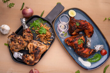 Crispy delicious chicken tandoori and Afghani chicken tandoori  with salad served in plate. Tandoori Chicken is an Indian non vegetarian spicy food