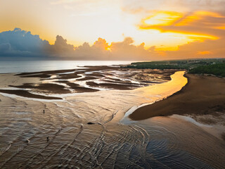 It was still early morning, the scene was quiet at the mouth of the river, as the golden color of...