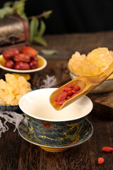 Traditional Chinese Medicine Goji Berries and Rock Sugar Herbal Tea Preparation on Wooden Table