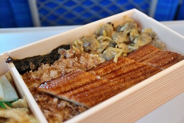 Japanese cuisine: Fukagawa-meshi (stewed clam and grilled conger eel over rice) bento box on Shinkansen in Tokyo, Japan