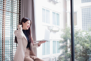 Fototapeta premium Smiling professional businesswoman in office, confident and ambitious, planning career goals, networking online, considering success, leadership, strategy, motivation, calm thinking.