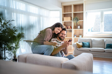 Obraz premium Happy couple making online payment using credit card and smartphone at home