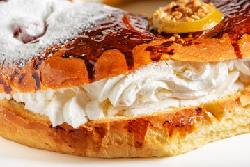 Extreme close-up of the cream filling of a Roscon de Reyes, with powdered sugar and candied fruit, a traditional sweet for Epiphany in Spanish culture.