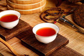 Traditional Chinese Tea Ceremony with Dark Red Tea in White Porcelain Cups on Bamboo Mat