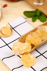 Yellow Rock Candy Sugar Crystals in Wooden Spoon - Traditional Handmade Sweetener with Mint Leaves