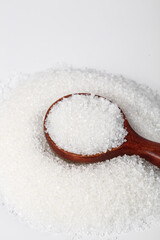 White Sugar Crystals in Wooden Spoon on White Background - Edible Sweetener Ingredient