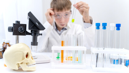 A boy conducts chemical experiments in a laboratory with a microscope