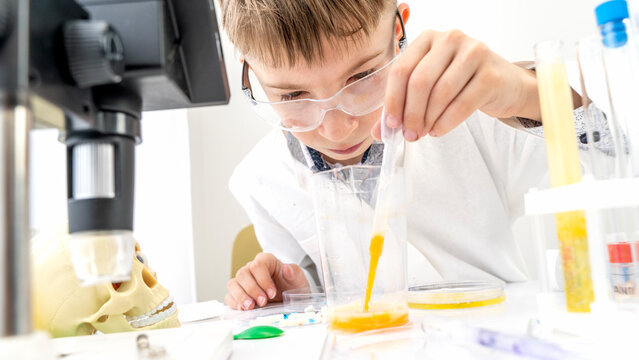 A boy conducts chemical experiments in a laboratory with a microscope