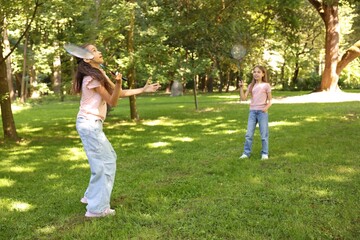 Obraz premium Cute little girls playing badminton in park