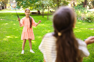 Cute little girls playing badminton in park, selective focus