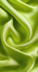 Obraz premium Close-up view of vibrant lime-green silk fabric, draped in soft folds and waves